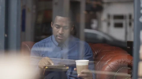 4K Portrait Smiling Man Sitting In Cafe Using Computer Tablet &amp; Drinking Coffee Video stock 75715071