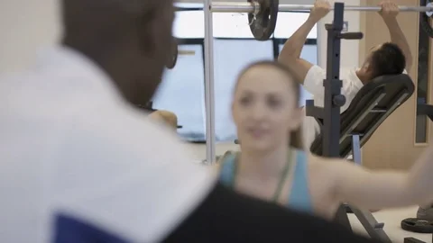 4K Portrait smiling personal trainer supervising a client in modern gym Stock Footage 75850650