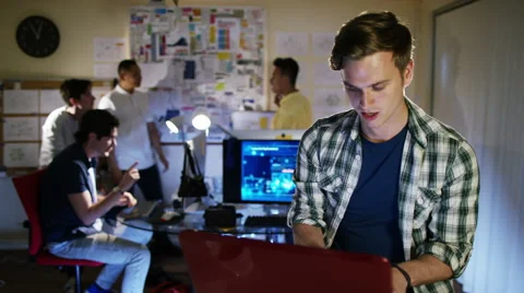 4K Portrait of smiling young computer programmer working in office with others Stock-Footage 54435256