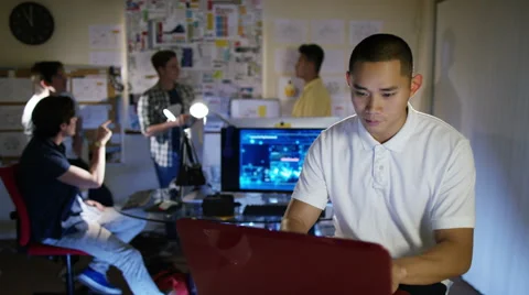 4K Portrait of smiling young computer programmer working in office with others Stock Footage 54436802