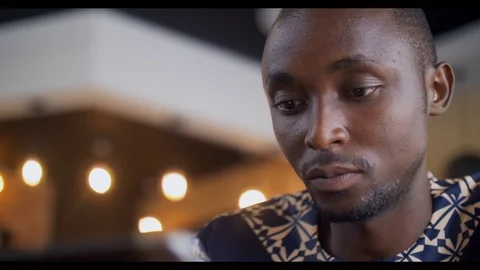 4k portrait of young african using ipod at busy coffee shop. Stock Footage 111339357