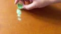4K Pouring green sparkling glamour makeup glitter on a wooden table 4k or 4k+ Resolution