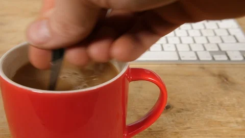 4K pouring a teaspoon of sugar in a Red cup of tea spinning in mug, hot drink Stock Footage 88502083