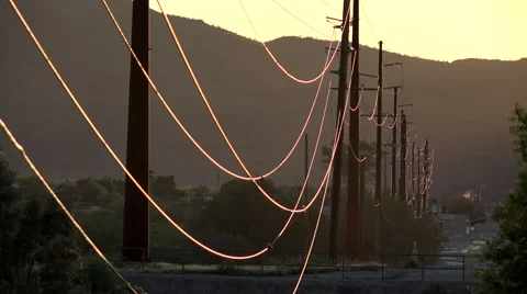 4K Power Transmission Energy Lines Glow At Sunset Stock Footage
