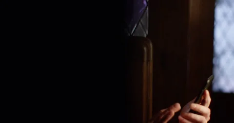 4k A priest taking out time to swipe through a dating app in between his prayer. Stock Footage 128407875