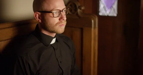 4k Priest talking on the phone to someone who is confessing to their sins. Stock Footage 128408091