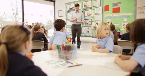 4K Primary school teacher talking to class of young children &amp; asking questions Stock Footage 74319162