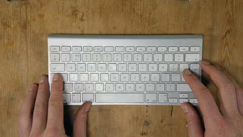 4K procrastinating on keyboard, While man working on computer at desk  Stock Footage 88245814