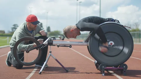 4K Professional disabled athlete training in racing chair on roller machine  Stock Footage 64581194