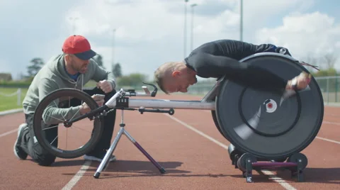 4K Professional disabled athlete training in racing chair on roller machine  Stock Footage 64581502