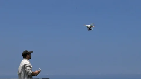 4K Professional man playing a drone with remote control. Flying quadrocopter-Dan Stock Footage 98780384