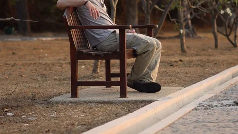 4K Protrait of Casual Young Man Sitting on Park Bench Outdoors in Nature Stock Footage 126259357