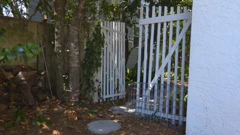 4K Push and Pull Towards Small White Backyard Gate Vidéo 109373836