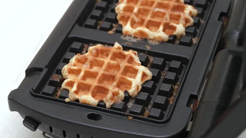 4K - Quick cooking of Belgian waffles in a waffle iron. Close-up Video stock 166041935