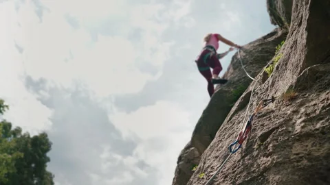 4K quickdraw on rock wall, female climber ascending in background Vidéo 344334105