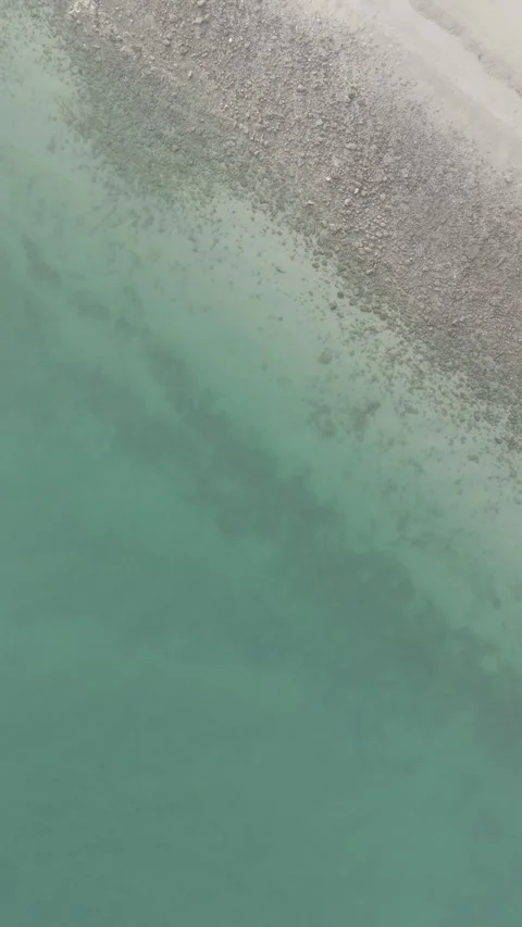 4K RAW Overhead View of Serene Shoreline with Turquoise Waters. Stock-Footage 299948398