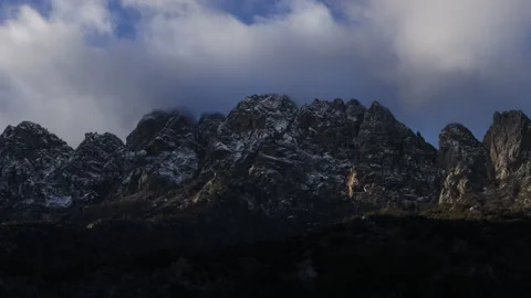 4K real time of approaching clouds in blue sky over dark, snowy Organ Mountains Stock Footage 229342324