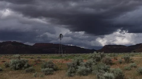 4K Real Time of dark summer rain clouds and a spinning old windmill in Arizona Stock Footage 214018597