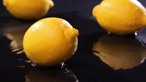 4K Real Time Falling Lemon Impact on Wet Black Surface Stock Footage 325981122