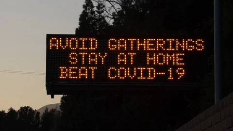 4K real time long shot of a COVID-19 stay home highway sign in Los Angeles 스톡 동영상 129337245