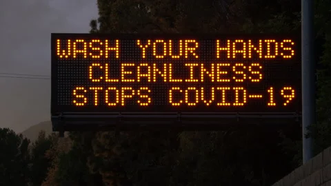 4K real time long shot of a COVID-19 wash hands highway sign in Los Angeles Stock Footage 130412698