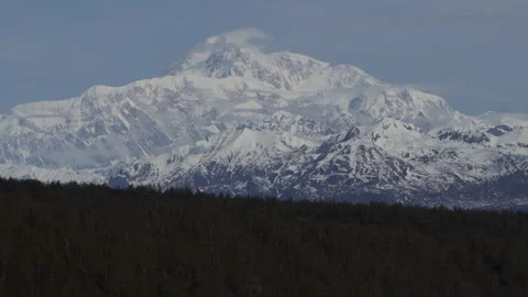 4K real time long shot of wispy spring clouds on a sunny Mount Denali in Alaska Stock Footage 242992115