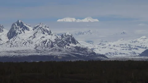 4K real time of Mount Hunter partly visible between clouds in the Alaska Range Stock Footage 245461488