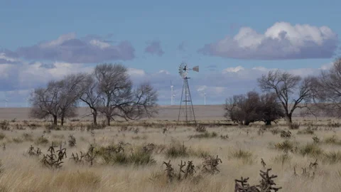 4K Real Time of an old windmill and modern windmills on the New Mexico prairie Stock Footage 229058420