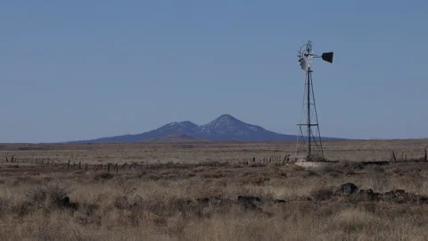 4K Real Time of an old windmill and distant peaks on the New Mexico prairie Stock Footage 260421384