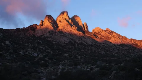 4K real time of pink Clouds in The Organ Mountains lit with sunrise sunlight Stock Footage 229228026