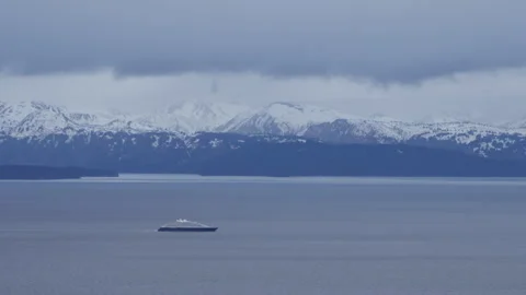 4K real time of a ship leaving snowy Kachemak Bay on a cloudy Alaskan day Stock Footage 243140054