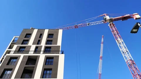 4k real time video of big crane moving over a new modern skyscraper building Stock Footage 148755084