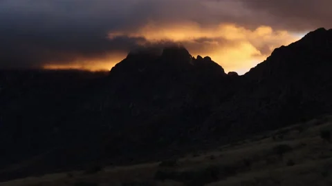 4K real time view of Orange Sunset Clouds blowing in The Organ Mountains Stock Footage 229214144