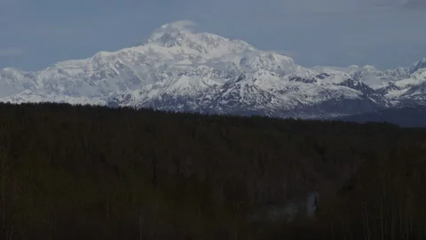 4K real time of wispy spring clouds on a sunny and snowy Mount Denali in Alaska Stock Footage 245465907
