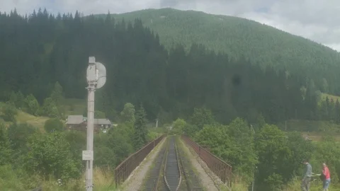 4K Rear view of huge mountain from dirty window of passenger train riding across Stock Footage 119776927