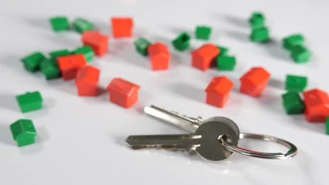 4K red and green board game toy houses with a set of door keys on a white  Stock Footage 90799553