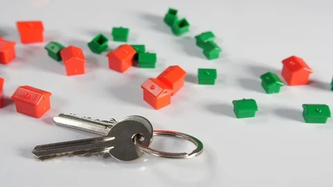 4K red and green board game toy houses with a set of two door keys on a moving Stock Footage 90800947