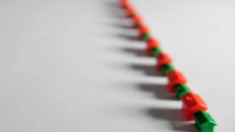 4K Red and green plastic houses in a row white background surface, represention Stock Footage 90805421