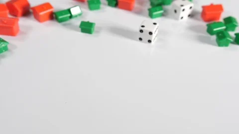 4K red and green toy house shapes with 2 rolling dice on a white surface back Stock Footage 90809864