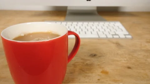 4K Red cup of tea spinning in mug, hot drink at computer work desk Stock Footage 88503052