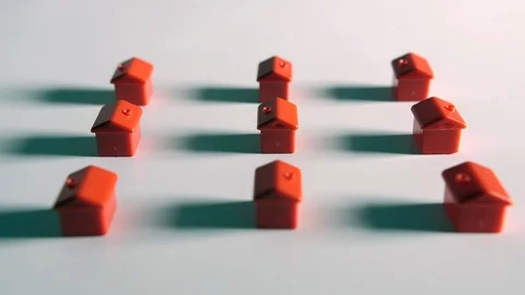 4K red plastic houses falling on a white background surface, representing houses Stock Footage 90817843