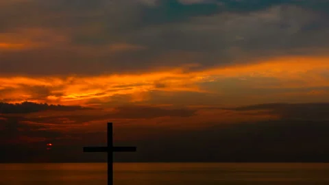 4К. Red sky with sun and Christian Cross. Sunrise over sea. RAW outpoot  Stockbeeldmateriaal 103465736