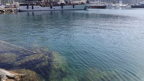4K Reflection of sunlight in the clear blue sea in the port at the pier Stock Footage 108102693