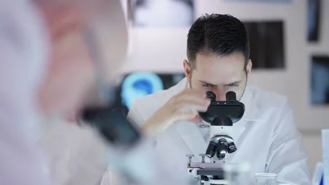 4K Research scientist working in the lab, analyzing a sample under microscope Stock Footage 69808614