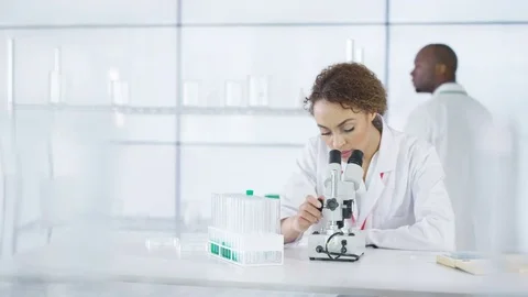 4K Research scientist working in laboratory, looking at sample under microscope. Stock Footage 73291175