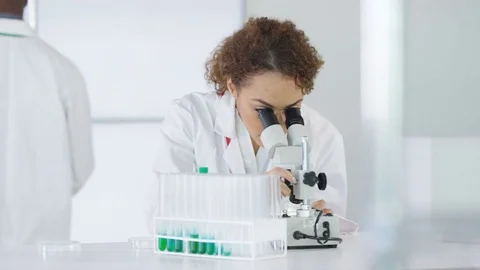 4K Research scientist working in laboratory, looking at sample under microscope. Stock Footage 73296215