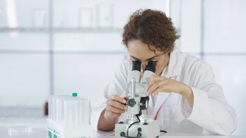 4K Research scientist working in laboratory, looking at sample under microscope. Stock Footage 73296788