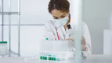 4K Research scientist working in laboratory, looking at sample under microscope. Stock Footage 73305274
