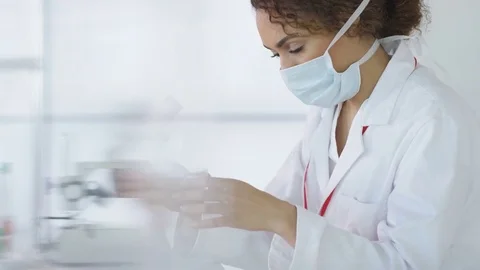 4K Research scientist working in laboratory, looking at sample under microscope. Stock Footage 73305521