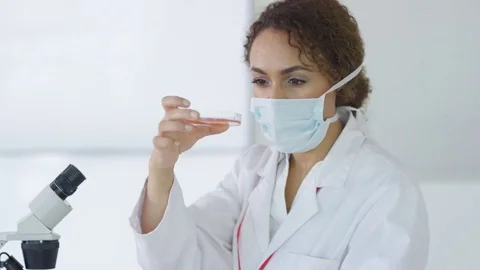 4K Research scientist working in laboratory, looking at sample under microscope. Stock Footage 73305679